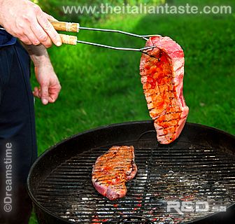 A man is grilling a big beefsteak