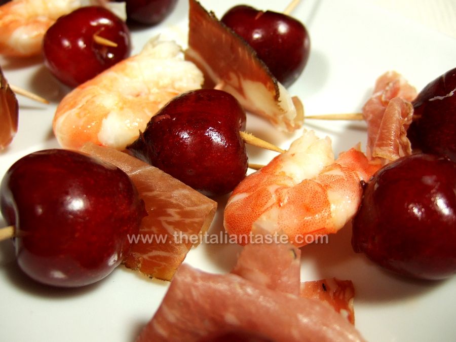 Skewers with fruit, salami and prawns